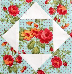 a blue and white quilt with red flowers on it