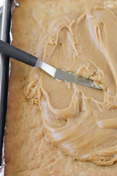 a knife is being used to spread peanut butter on bread