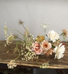 a vase filled with flowers sitting on top of a wooden table