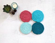 "Brighten up your home decor with this charming hand knit coaster set. Handmade coasters are perfect for your coffee table, desk, dining room table, nightstand, end table or anywhere you want to add some color and style.  Use them under your morning cup of coffee, or under a candle for a cute accent.  The top of these drink coasters is knit with 100% cotton yarn, perfect for absorbing drink condensation.  The bottom has an attached round cork pad, protecting your surface from heat or cold. No more scratches or rings on your furniture. Each set includes 4 coasters in complementary colors.  Coaster sets are great gifts for: hostess, housewarming, bridal shower, holiday, thank you, teacher, birthday or thinking of you!  Add a touch of handmade luxury to your home with Hand Knit Coil Coaster S Desk Dining Room, Knit Coasters, Gifts For Hostess, Knit Coaster, Rugs Modern, Handmade Coasters, Knitting Gift, Mug Rugs, Christmas Knitting