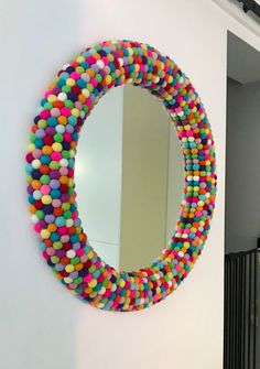 a mirror that is hanging on the wall with some balls around it and a bunch of other things in front of it