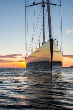 a sailboat in the ocean at sunset