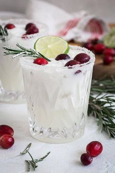 two glasses filled with ice and garnished with cranberries