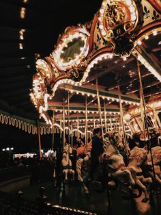 a merry go round at night with many people on the carousel and lights all around