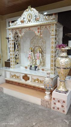 an ornate white and gold display with vases