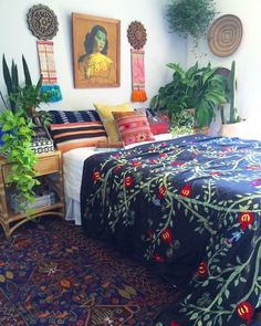 a bedroom with a bed, plants and pictures on the wall