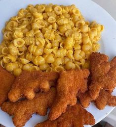 some fried food on a white plate with macaroni and cheese