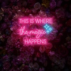 a neon sign that says, this is where the magic happens in front of flowers