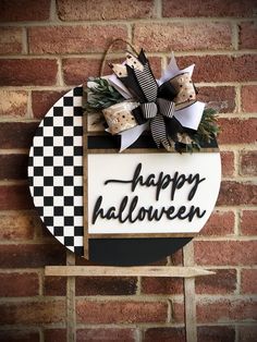 a sign that says happy halloween hanging on a brick wall