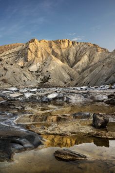 the mountains are covered in snow and ice as it sits on top of some rocks