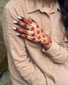 a woman is holding her hands with hendi designs on it's palms and arms