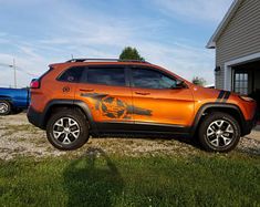 an orange jeep parked in front of a house