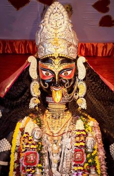 an elaborately decorated mask is displayed in front of a bed