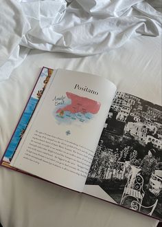 an open book sitting on top of a bed