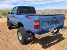 a blue toyota pickup truck parked in the desert