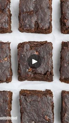 chocolate brownies are arranged in rows on a sheet of white paper with the video below them