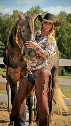 a woman standing next to a brown horse