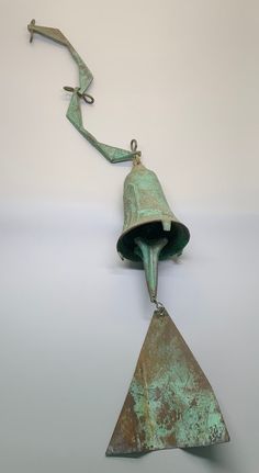 an old metal bell hanging from a hook