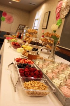 an assortment of desserts are lined up on a buffet table