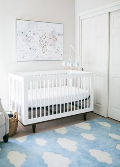 a baby's room with a blue rug and white crib