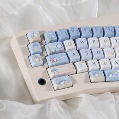 a blue and white computer keyboard with snowmen on it's backlit keys