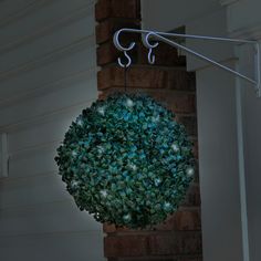 a lighted ball hanging from the side of a house