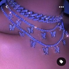 the back of a woman's neck with butterflies on it and chains attached to her chest