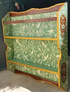 a green and yellow painted bench with birds on it