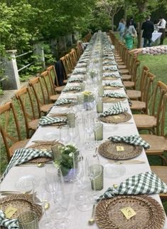 a long table is set with place settings and place settings for the guests to sit at