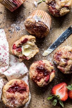 strawberry muffins with powdered sugar and fresh strawberries on the table next to them