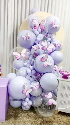 a bunch of balloons that are in the shape of animals and butterflies on a table