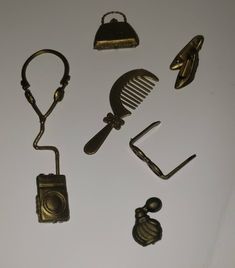 various antique items are displayed on a white surface with clippings and clips attached to them