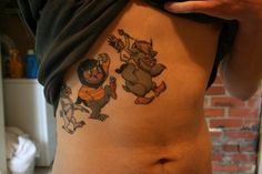 a woman's stomach with tattoos on it and an image of cartoon characters painted on the side