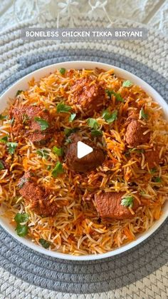 chicken tikka biriyani served in a white bowl on a gray place mat