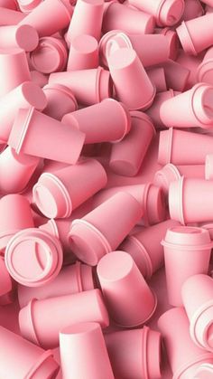 a large pile of pink plastic cups and lids