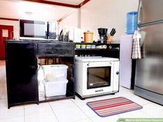 a microwave oven sitting inside of a kitchen next to a refrigerator