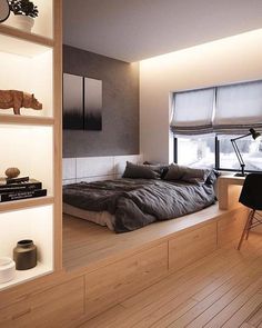 a bed sitting on top of a wooden floor next to a window