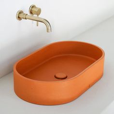 an orange sink with a faucet on the side