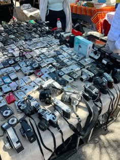 a table topped with lots of different types of cameras