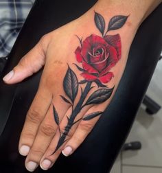 a woman's hand with a rose tattoo on it