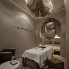 a spa room with a large mirror above the bed and a small table in front of it