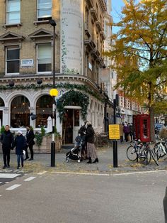 people are walking down the street in front of buildings