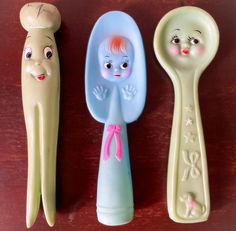 three plastic spoons with cartoon faces on them