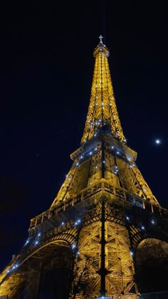 the eiffel tower lit up at night with lights on it's sides