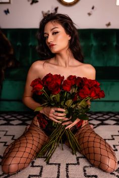 a woman sitting on the floor with roses in her hands