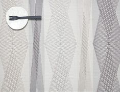 a black and white photo of a spoon on a curtain with wavy lines in the background