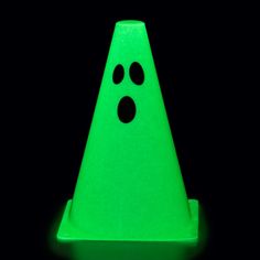 a green traffic cone with two black dots on the bottom and one white dot at the top