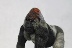 a gorilla figurine is shown on a white background with an orange spot in it's eye