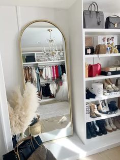 a closet with shoes, handbags and purses on shelves next to a mirror