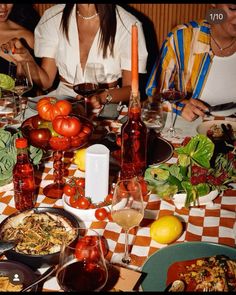 people sitting at a table with food and wine